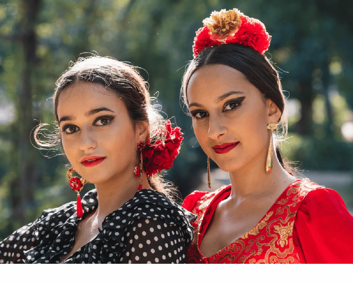 Two women in vibrant flamenco-style dresses with flawless brows ready for Cinco de Mayo celebration in Escondido